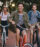 Three young people cycling down the street.